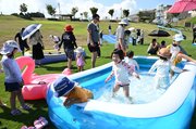 芝生広場に設置されたプールで歓声を上げる子どもたち＝氷見市朝日山公園見晴らしの丘