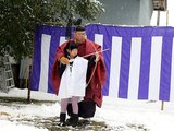 宮司に教わりながら矢を引く児童