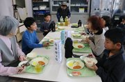 会食を楽しむ児童と住民ら＝立山町釜ケ渕小学校