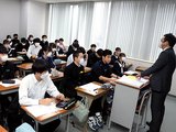 講師（右）の話を聞く中学３年の受講生たち＝富山育英センター富山本部校中学部