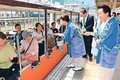 黒部ダムの流木しおりどうぞ　かたかご会らが環境配慮の活動発信、宇奈月駅で乗客に贈る