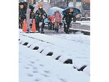 ３学期が始まり、雪の中を通学する児童＝８日午前７時４０分ごろ、富山市新庄銀座