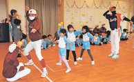 園児に投球フォームを教える部員