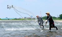 川面に網を投げ入れる愛好者＝神通川婦中大橋下流