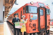 新しいヘッドマークを披露する小川部長（左）と佐藤さん。車両に取り付けてあるヘッドマークは２０２０年に作成したもの