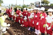 球根の植え方を教わる児童