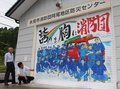 防災、亡き仲間と心一つ　氷見市消防団阿尾地区センターがシャッター新調、イラストに分団員集合