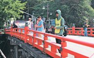 アリゲーターガーを捕まえようと、釣りざおを伸ばす参加者＝高岡古城公園
