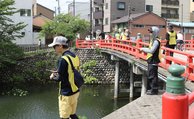 アリゲーターガーを釣ろうと、さおを伸ばす参加者＝高岡古城公園