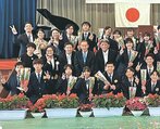 大居さん（中列左から４人目）と谷さん（同３人目）と一緒に、チューリップを手に写真に納まる卒業生