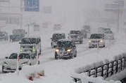 激しく雪が降る中、速度を落として国道８号を走る車の列＝５日午前７時５０分ごろ、魚津市吉島