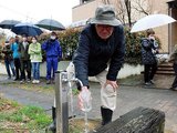 蛇口から出てきた井戸水を確認する住民