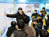 町職員（奥左）から海洋深層水の特徴を聞く子どもたち＝海洋深層水活用施設