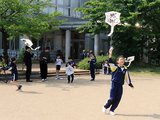 グラウンドで凧揚げを始める児童
