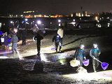 波打ち際に現れるホタルイカを探す人たち＝３０日午前１時１５分ごろ