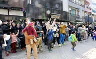 餅や菓子をつかもうと手を伸ばす住民や観光客ら
