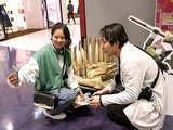 モンスターの骨の模型と写真を撮る買い物客＝三井アウトレットパーク北陸小矢部