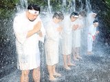 水しぶきを上げながら滝に打たれる参拝者＝大岩山日石寺