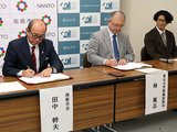 協定書に署名する田中市長（左）と林院長（中央）