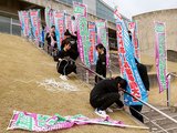 選手らを歓迎するのぼり旗を設置する氷見高ハンドボール部員＝氷見市ふれあいスポーツセンター