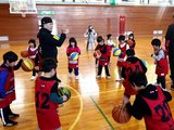 竹原さんに教わり、ドリブルを練習する児童＝県砺波青少年自然の家体育館