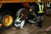タイヤに布製チェーンを取り付ける参加者