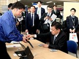 ロコピ登録したマイナカードを端末にかざし、ポイントの付与を受ける松本デジタル相（手前右）＝朝日町役場