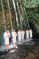 手を合わせ滝に打たれる人たち＝大岩山日石寺