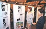 本紙記事のパネル展示を見て世界遺産に登録された当時を振り返る住民＝塩硝の館