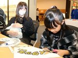 「ハイタッチして!」のメッセージを切り取る子ども