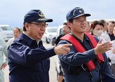 物資輸送の投下訓練は新田知事(左)が視察した=入善町芦崎