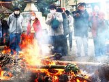 燃え上がる炎に向かって祈ったり手をかざしたりする住民
