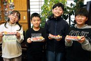 出来上がりを手に笑顔を見せる子どもたち