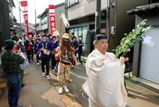街中を巡行する神職と地元住民＝射水市本町