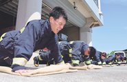 防火服を身に着け、腕立て伏せをする消防隊員＝富山市今泉