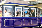 オープン記念便のトレーンに乗って手を振る来場者