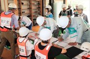 訓練で避難後の受け付け手続きをする住民＝浦山交流センター
