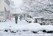 降り積もった雪の中を歩く人たち＝４日午後０時１５分ごろ、砺波市山王町（上田友香撮影）