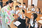 葛野さん（左）に教わりながら能の世界を学ぶ児童　＝滑川市西部小学校