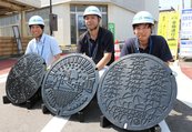 ３市のシンボルがあしらわれたマンホール＝ＪＲ伏木駅前