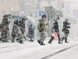 降りしきる雪の中を歩く人たち＝１８日午後０時１０分ごろ、富山市中央通り