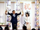 笑顔でタイを両手に持つ藤井氏