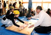 手ほどきを受けながら、そば打ちに挑戦する子どもら＝南砺市利賀村の上村公民館