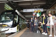 くす玉を割り、ラッピング電車の出発を祝う関係者＝富山駅