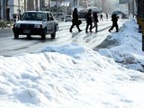 道路脇にかためられた雪の上に、うっすらと新雪がつもった＝１８日午前８時半ごろ、富山市千歳町