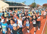 一斉にスタートするハーフマラソンの出場者＝入善町中央公園陸上競技場
