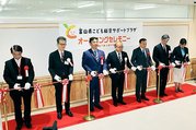 県こども総合サポートセンターの前でテープカットする関係者＝富山市新富町