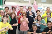 手話で「デフリンピック」を表現する大西選手（後列左から３人目）や夏野市長（同４人目）ら＝射水市役所